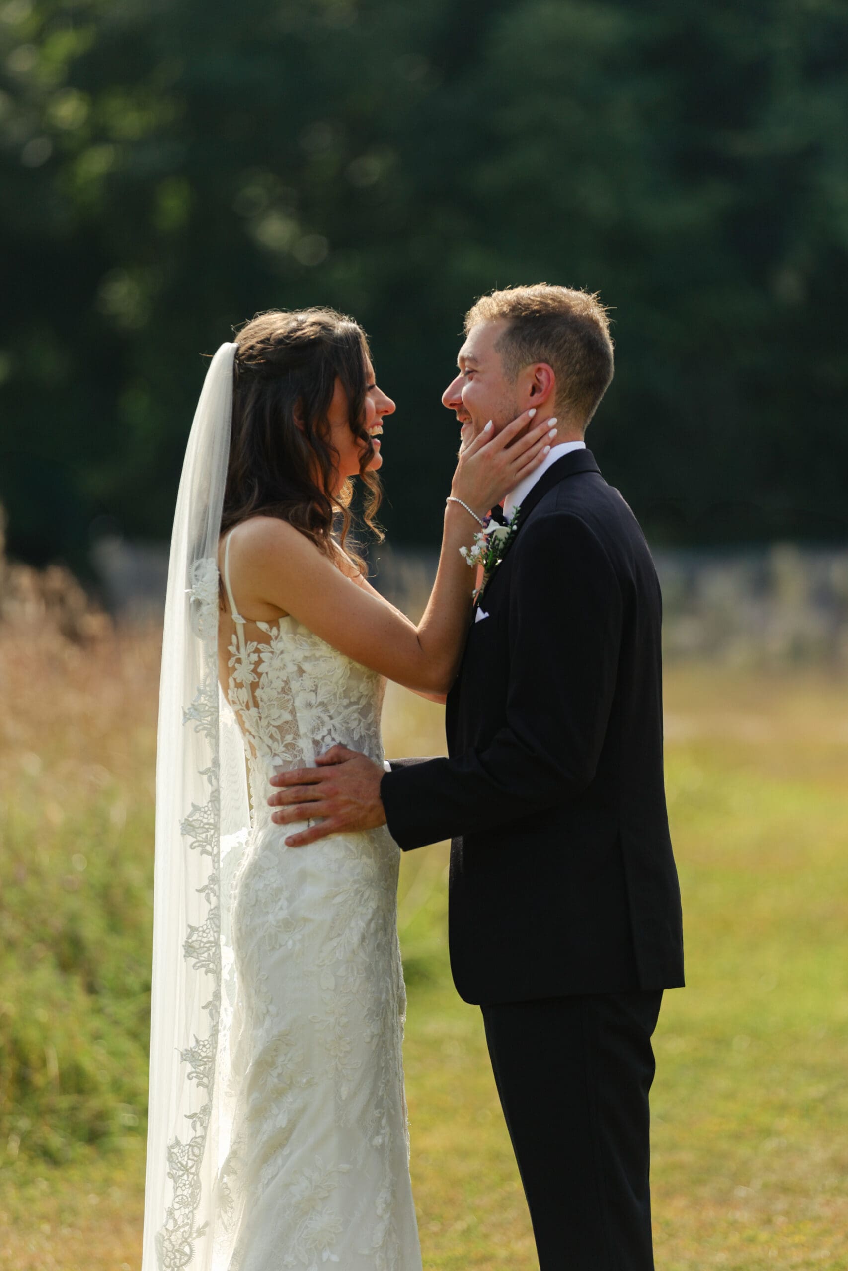 bride and groom portraits in a grassy field in the summer candid documentary photography